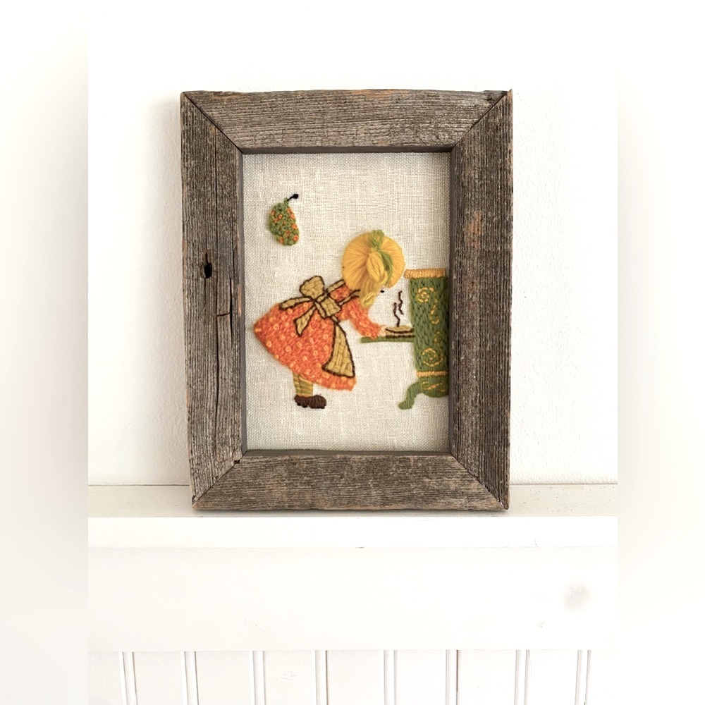 Vintage crewel embroidered girl baking.